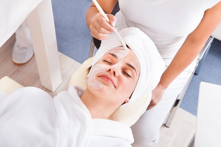 Esteticista aplica máscara facial a la cara